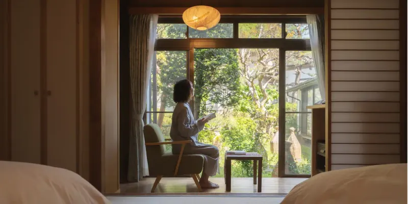 Guest sitting by the garden window at Kamei no Yu ryokan in Yudanaka near the snow monkey park
